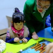 Teacher implementing a play-based toddler curriculum in classroom